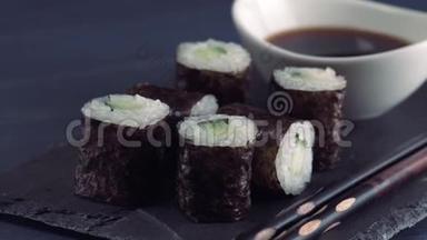 日本餐厅，寿司卷在黑色石板板上。 定一人用筷子，生姜，<strong>黄豆</strong>..